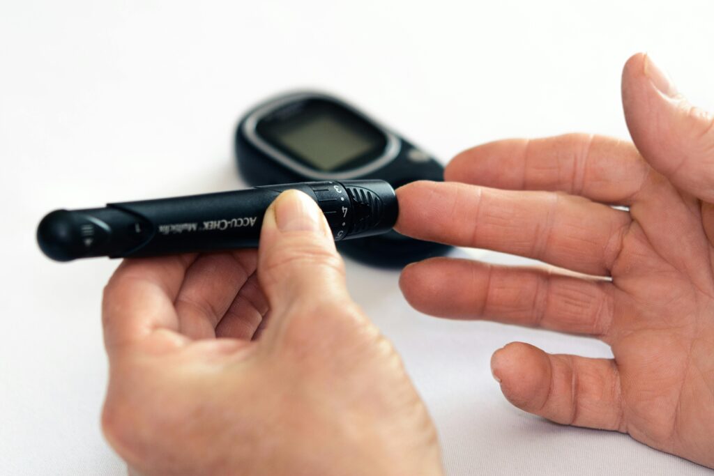 Close-up image of a person using a glucometer for diabetes management indoors.